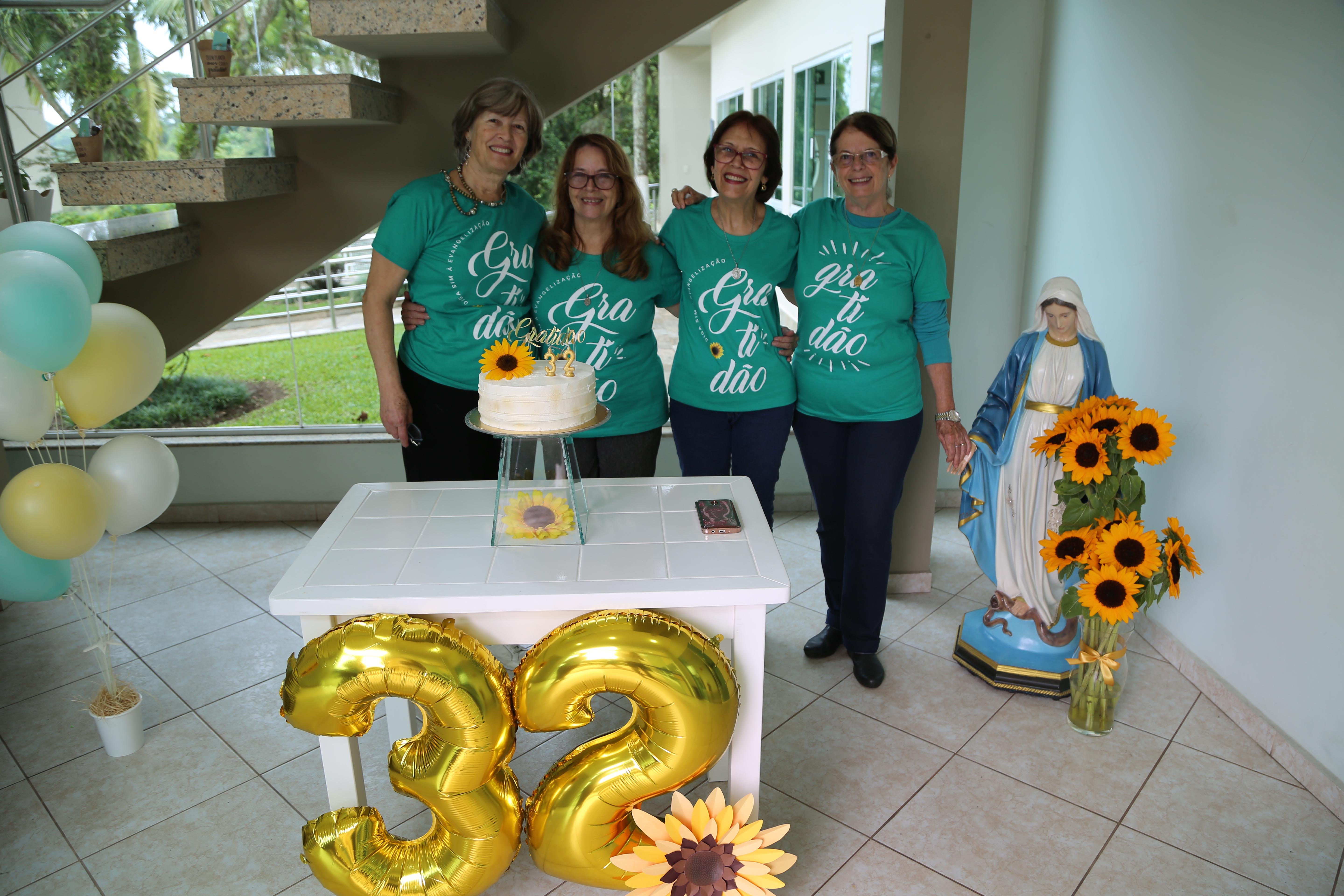Voluntárias da MI reunidas para cortar o bolo de aniversário da Obra
